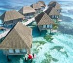 Stunning aerial view of overwater bungalows in Fuvahmulah, Maldives, with crystal clear waters.