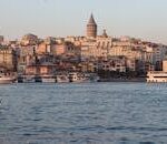 A breathtaking view of the Galata Tower and Istanbul's vibrant waterfront at sunset.