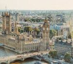 Stunning aerial view of London's iconic Big Ben and the river Thames under daylight.