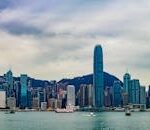 Stunning view of Hong Kong's skyline from Kowloon at sunset, featuring modern skyscrapers.