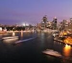 Captivating view of Sydney's illuminated skyline with the iconic Opera House and harbor at night.