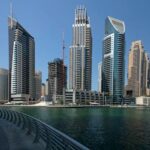 Explore the stunning skyline of Dubai Marina with modern skyscrapers reflecting on the waterfront.